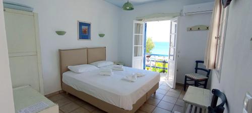 a bedroom with a bed with a view of the ocean at Lodge Narlis in Platis Gialos