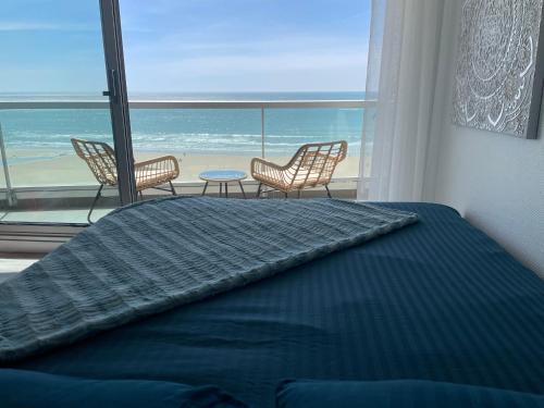 um quarto com uma cama e vista para o oceano em Face Mer vue d'exception Studio rénové au 9ème étage em Les Sables-dʼOlonne