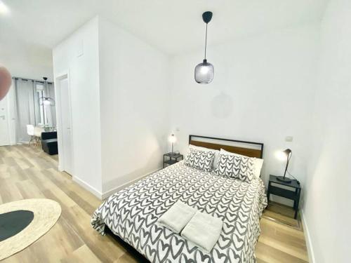 1 dormitorio con 1 cama con edredón blanco y negro en Madrid Rio Amparo Usera, en Madrid