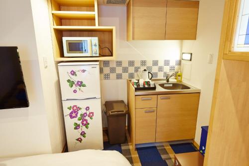 a small kitchen with a refrigerator and a sink at Hotel Sanriiott Kitahama - Vacation STAY 33498v in Osaka