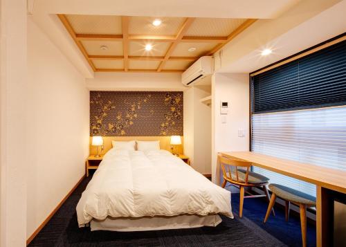 1 Schlafzimmer mit einem Bett und einem Schreibtisch sowie einem Bett der Marke sidx sidx sidx. in der Unterkunft Hotel Sanriiott Kitahama - Vacation STAY 33596v in Osaka