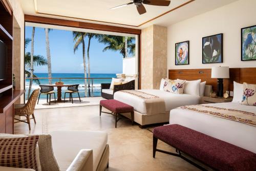 una camera d'albergo con due letti e vista sull'oceano di Dorado Beach, a Ritz-Carlton Reserve a Dorado