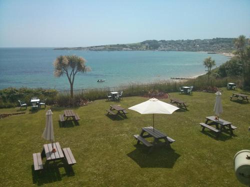 a group of picnic tables and an umbrella on the grass at Grand Hotel Swanage in Swanage