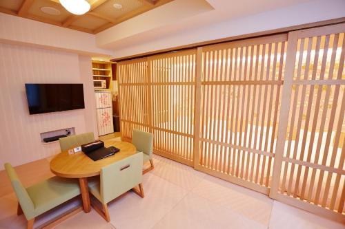 una sala da pranzo con persiane in legno, tavolo e sedie di Hotel Sanriiott Kitahama - Vacation STAY 33509v ad Osaka