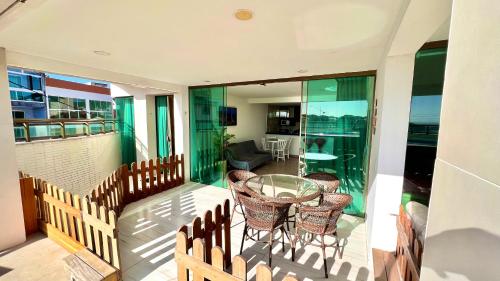 balcón con mesa de cristal y sillas en APARTAMENTO VISTA MAR Até 7 pessoas, en Arraial do Cabo