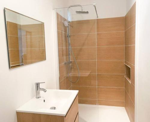 un bagno con doccia, lavandino e specchio di Proche festival - centre - lave-linge - wifi fibre ad Avignone