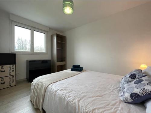 a white bedroom with a bed and a television at Gîte La Clé de Saint-Jean in Ergny