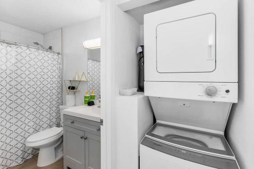 a white bathroom with a toilet and a washing machine at Citrus Blossom with Pool and Parking in Phoenix