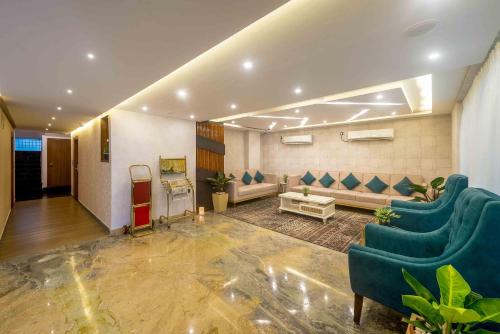 a living room with blue chairs and a couch at Royal Ace Boutique Hotel - Manyata Techpark in Bengaluru