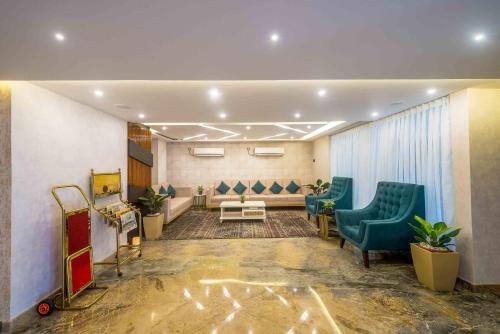 a waiting room with green chairs and a waiting table at Royal Ace Boutique Hotel - Manyata Techpark in Bengaluru