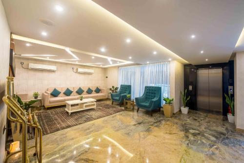 a waiting room with blue chairs and a couch at Royal Ace Boutique Hotel - Manyata Techpark in Bengaluru