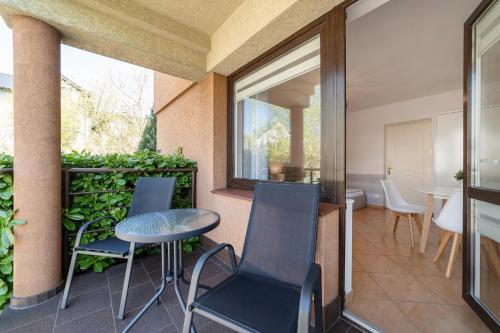 a balcony with chairs and a table and a window at Mario Pokoje - Apartamenty in Jastarnia