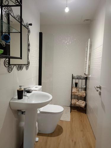 a white bathroom with a toilet and a sink at Ocean in Orio