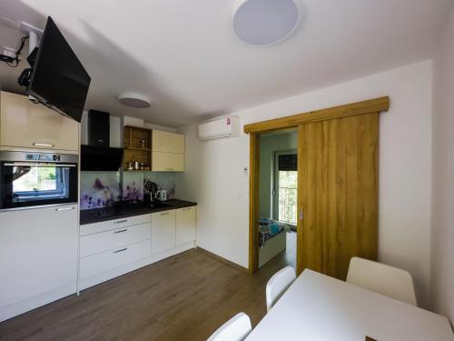 a kitchen with white cabinets and a table with chairs at APARTMAJI SILVA in Slappe dʼIdria