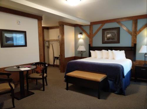 um quarto de hotel com uma cama, uma mesa e cadeiras em The Haber Motel em Estes Park