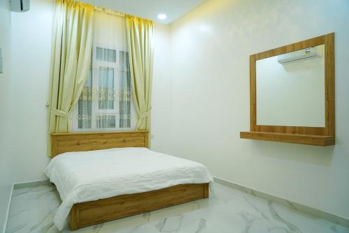 una camera da letto con un letto e uno specchio a parete di Bahja Challet a As Suwayq