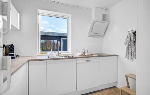 een witte keuken met een wastafel en een raam bij Awesome Home In Hornslet With 2 Bedrooms And Wifi in Hornslet