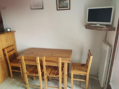 Cette chambre dispose d'une table et de chaises en bois. dans l'établissement Studio La Rosière 1850, à Montvalezan