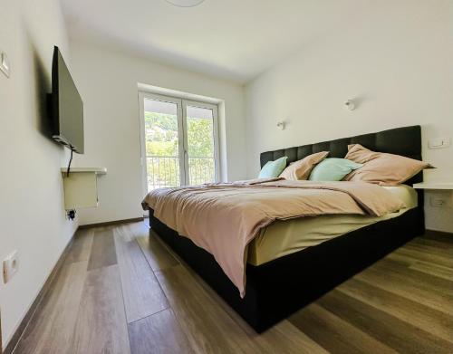 1 dormitorio con 1 cama grande y TV en APARTMAJI SILVA, en Slap ob Idrijci