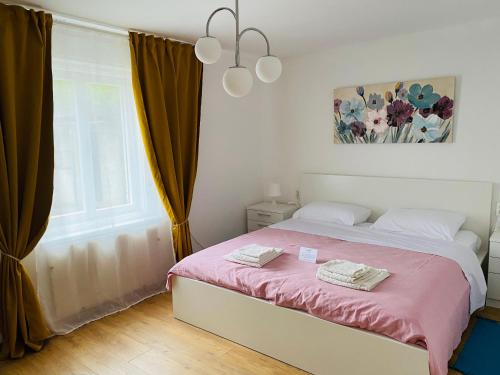 um quarto com uma cama com lençóis cor-de-rosa e uma janela em Apartment Sea you em Lovran
