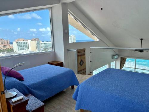 a bedroom with two beds and a large window at Penthouse 1AB on the beach with sea views in Cancún