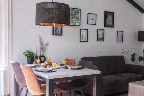 a dining room with a table and a couch at Vakantiehuisje verhuur - Heuvel 35 in Simpelveld