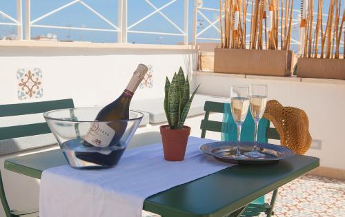 a table with a bottle of wine and glasses on it at NEREA - Apulian Suite and Rooms in Monopoli