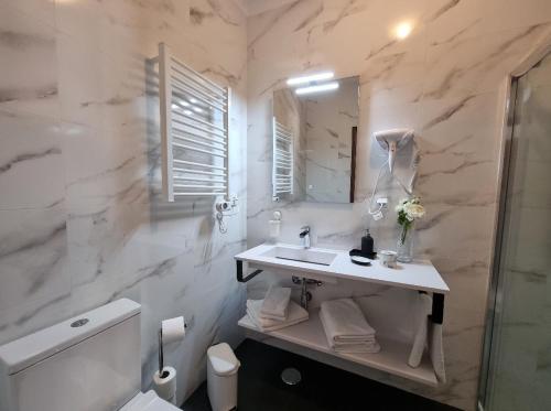 y baño con lavabo, aseo y espejo. en Apartmento Praia da Dona Ana, en Lagos