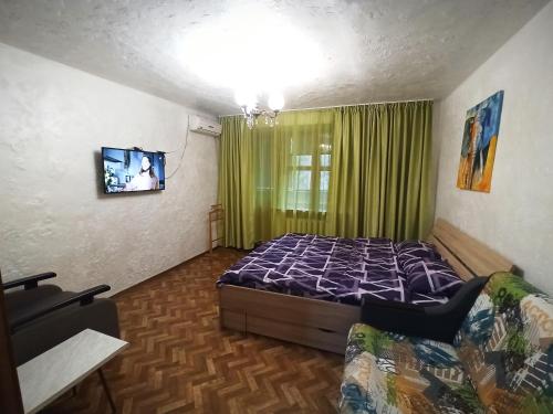 um quarto com uma cama e uma televisão em 3 кімнатна квартира на вул. Калинова. em Dnipro