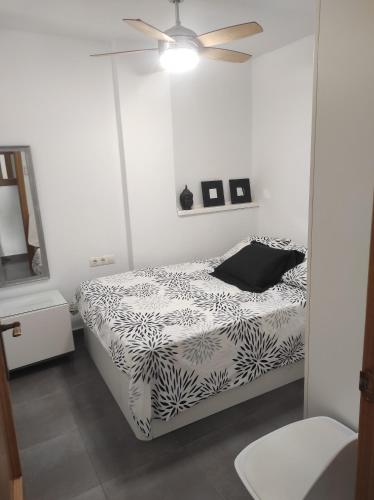 a bedroom with a bed and a ceiling fan at Apartamento CANDELA in Fuengirola