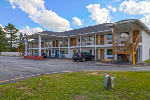 un grand bâtiment de motel avec un parking dans l'établissement Economy Inn By OYO Ashburn, à Ashburn