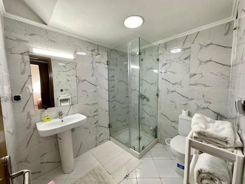 a bathroom with a shower and a sink and a toilet at Rabat, Appartement Neuf en face d'Arribat Center. in Rabat