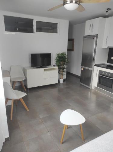 a kitchen with white appliances and tables and chairs at Apartamento CANDELA in Fuengirola