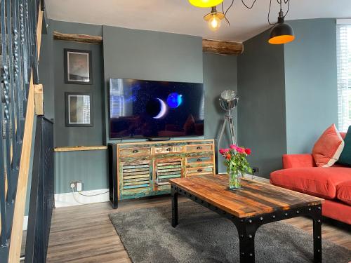 a living room with a red couch and a tv at High Street Apartment in Windermere