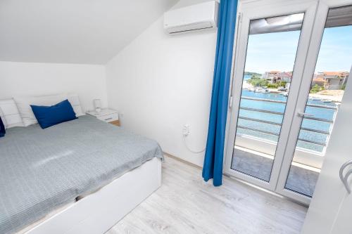een slaapkamer met een bed en uitzicht op de oceaan bij Apartment Bosiljka in Rogoznica