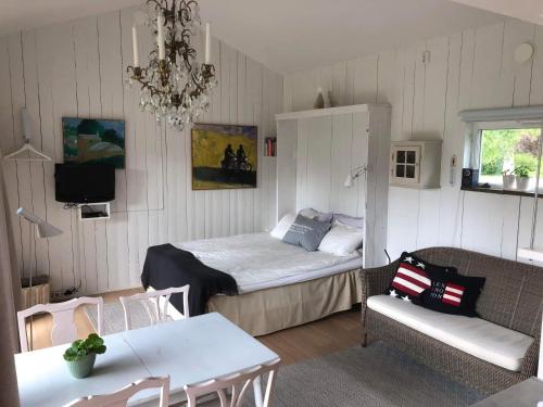 a bedroom with a bed and a couch and a table at Strandboende in Beddinge Strand