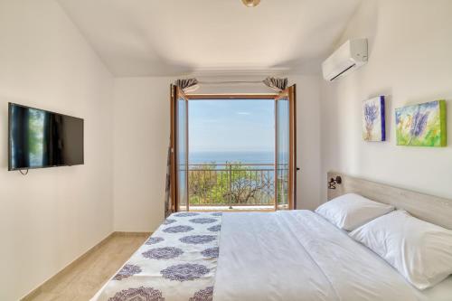 a bedroom with a bed and a large window at Seaview Villa Lavanda with pool in Budva