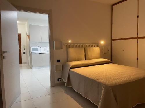 una camera con letto e porta di accesso a una cucina di La Casa di Mia a Cagliari