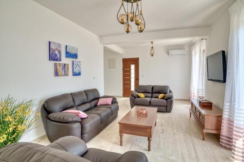 a living room with two couches and a tv at Seaview Villa Lavanda with pool in Budva