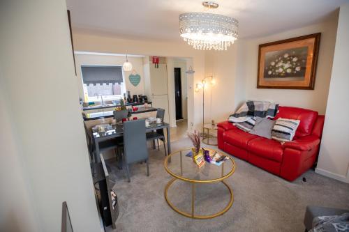 a living room with a red couch and a table at OG Tranquil Homes - Contractor & Family Friendly, FREE WiFi & Parking, Laptop friendly, Garden in Sunderland