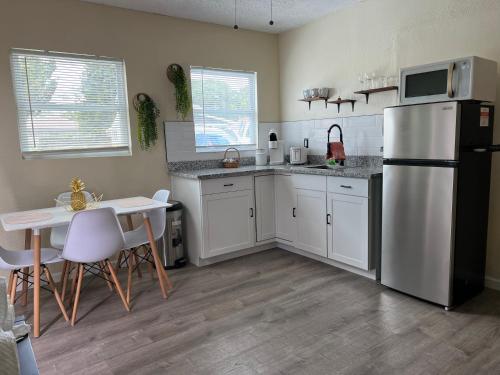a kitchen with a refrigerator and a table with chairs at Apartment near TPA Airport in Tampa