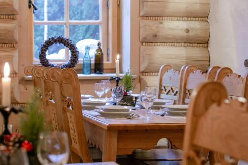 a wooden table with plates and wine glasses on it at Góralski Gościniec & SPA in Poronin