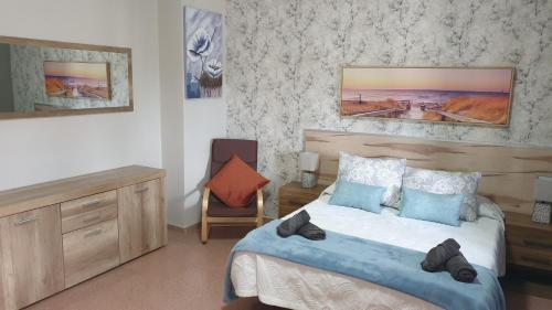 Un dormitorio con una cama y una silla dentro. en BrisaMarTelde, en Telde