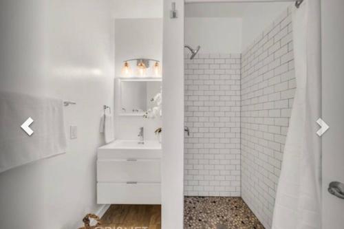 een witte badkamer met een wastafel en een douche bij 5080 Avenida Oriente in Los Angeles