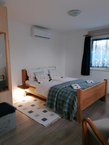 a bedroom with a bed and a window at Marianna Apartman in Gyenesdiás