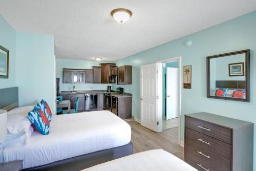 a bedroom with two beds and a kitchen at Admiral's Quarters in Kure Beach