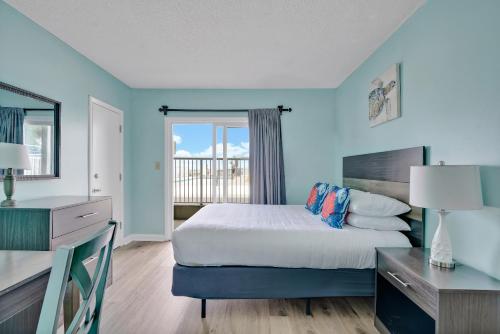 sypialnia z łóżkiem, biurkiem i oknem w obiekcie Admiral's Quarters w mieście Kure Beach