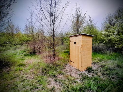 a wooden box sitting in the middle of a field at Maringotka Za Trnkou in Točník