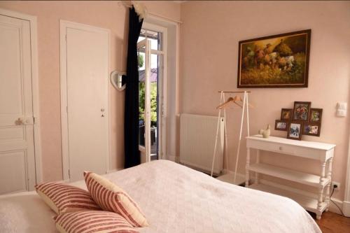 a bedroom with a bed and a table and a window at Gîte chez Madeleine in Louhans