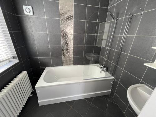 bagno con vasca e lavandino di 3 bed luxury open plan living a Rayleigh